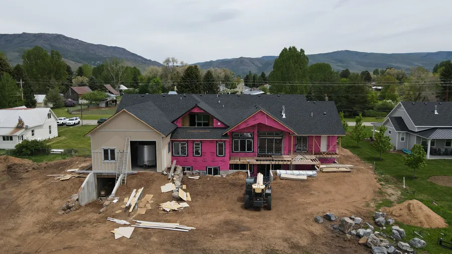 Rear elevation of the Huntsville custom home dried in, with roof, wrap, and windows installed