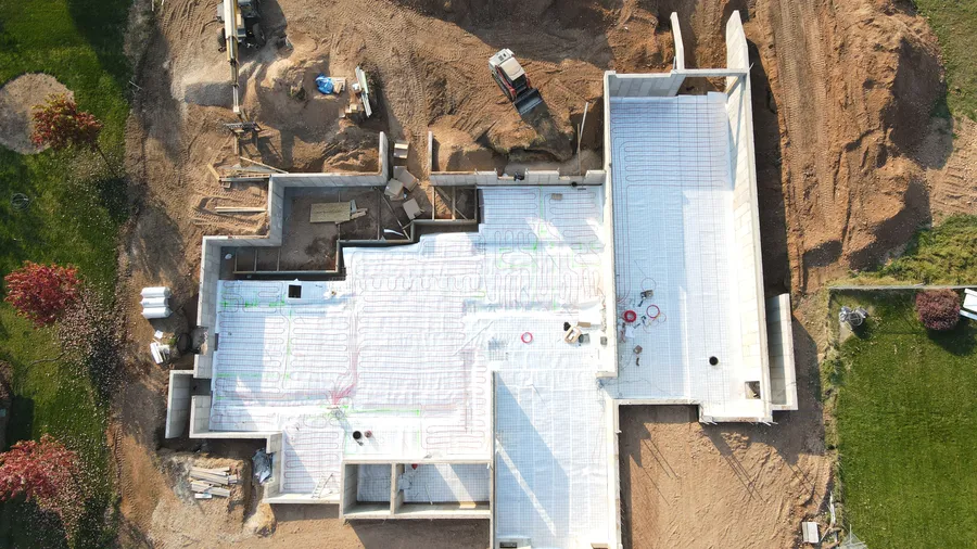 Top-down drone view of in-floor radiant heat tubing laid out before the slab pour