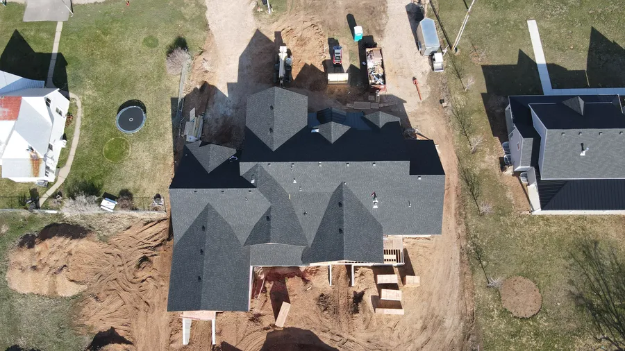 Top-down drone view of the completed architectural shingle roof on the Huntsville custom home